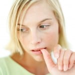 Young Woman Biting Her Finger Nail Young Woman Biting Her Finger Nail